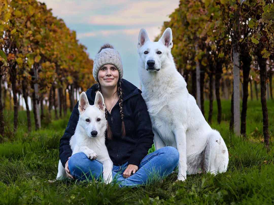 Samanta with Buddy and Ace sitting on the grass