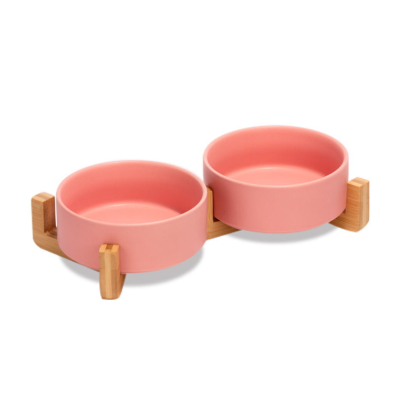 two cute pink dog bowls as a set on the bamboo stand