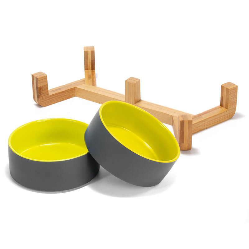 separate placed 2 grey-yellow clashing ceramic dog bowls and the bamboo stand