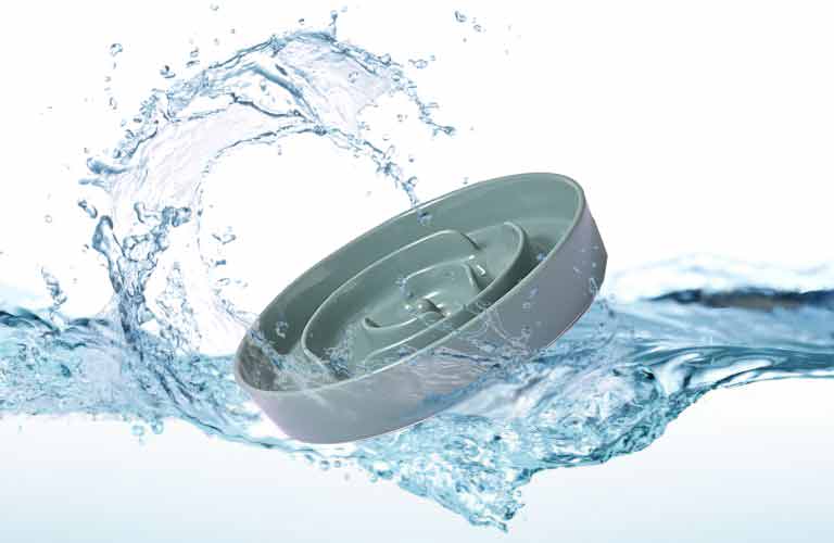 a dark green SpunkyJunky® Slow Feeder Dog Bowl is falling into the water