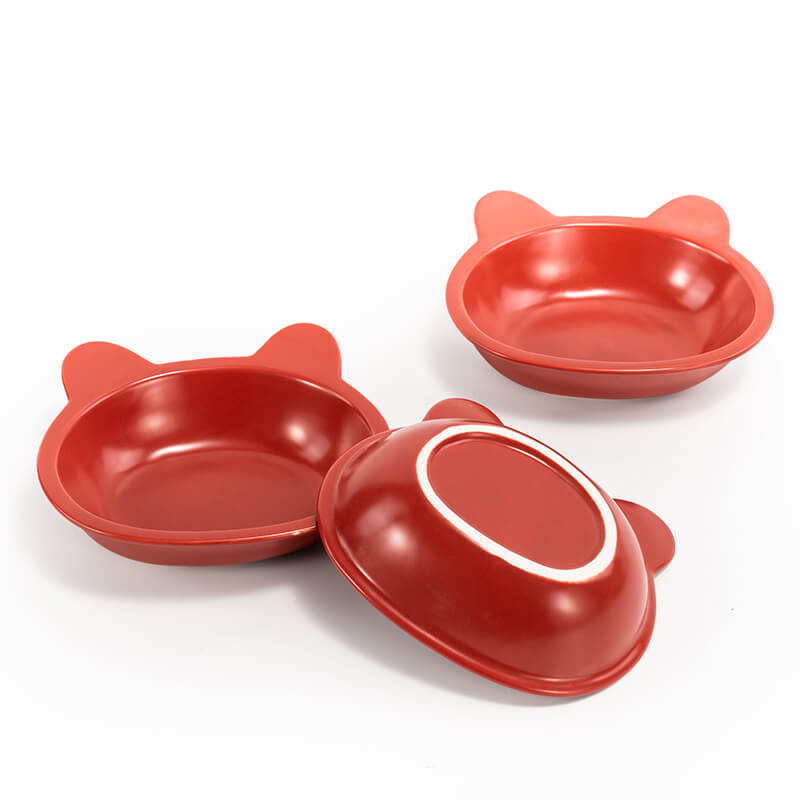 two front-facing, and one bottom-facing placed red ceramic cat-shaped dishes