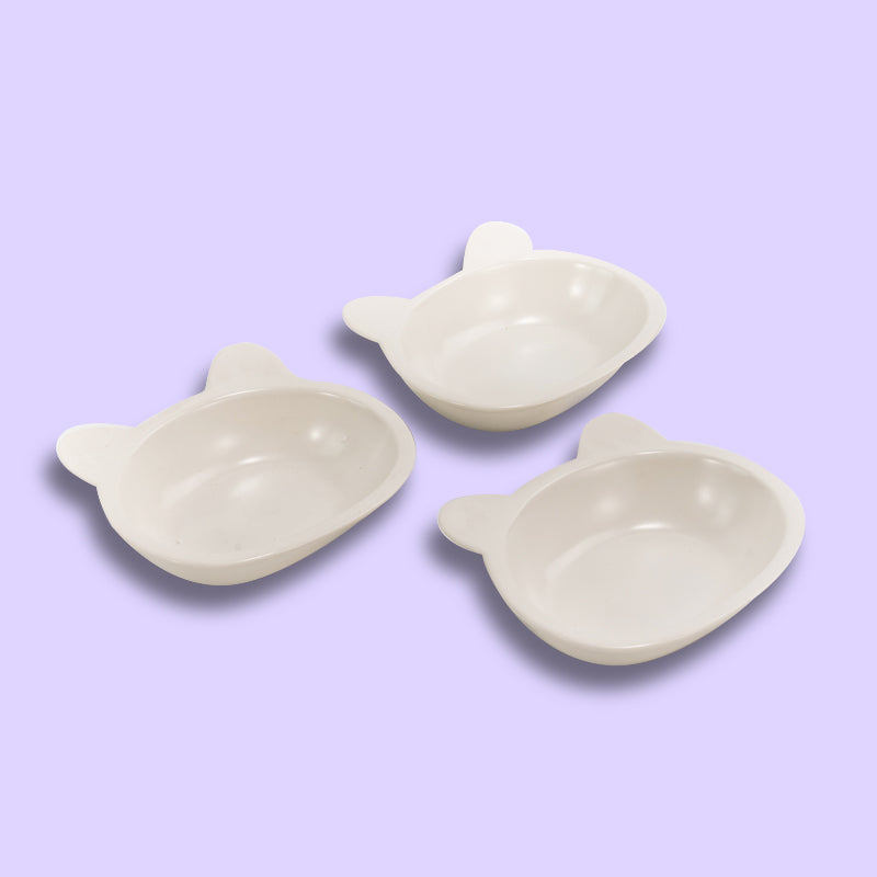 three neatly placed lovely white cat-shaped cat dishes in the purple background