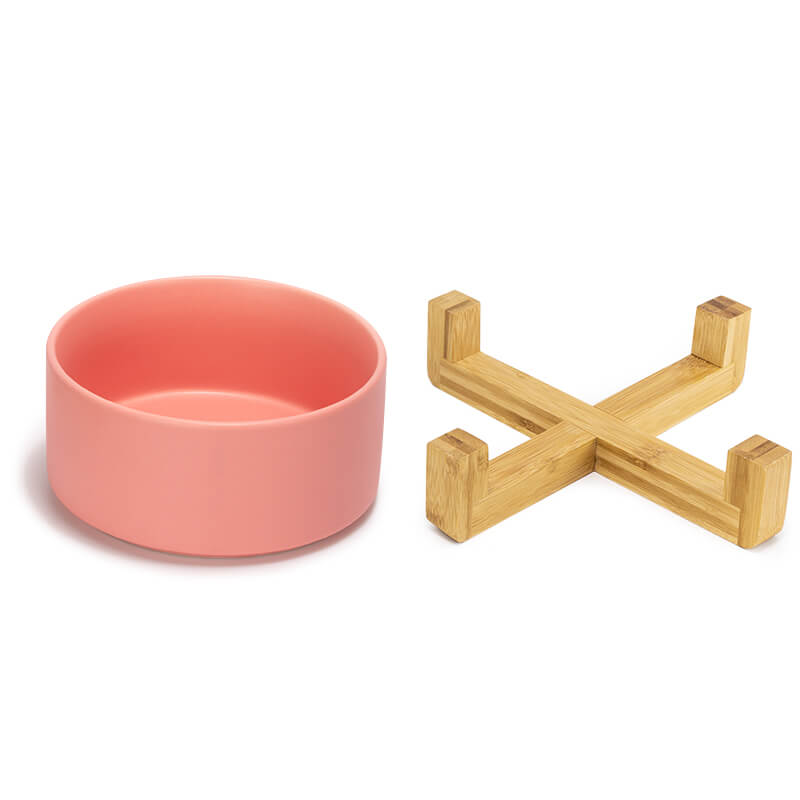 a cute pink dog bowl and the bamboo stand are placed separately