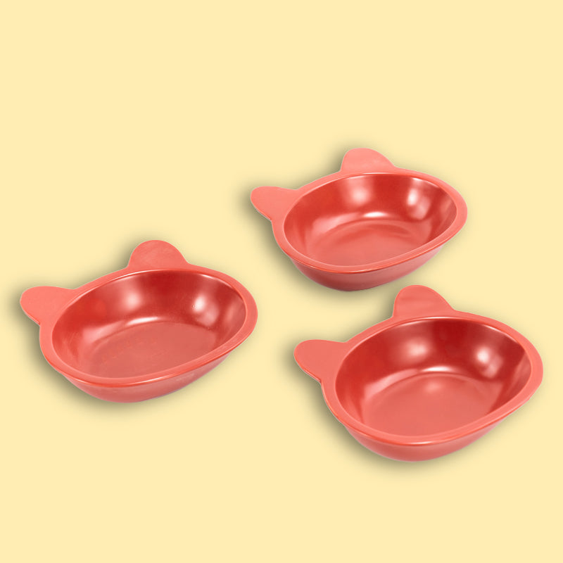 three neatly placed lovely red cat-shaped cat dishes in the yellow background