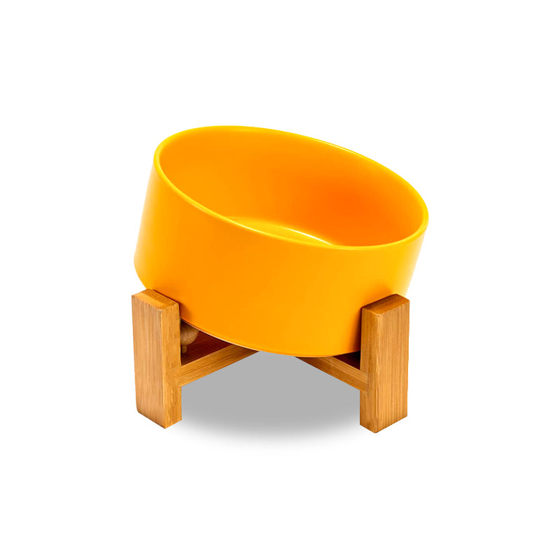 A single yellow tilted dog bowl of front view