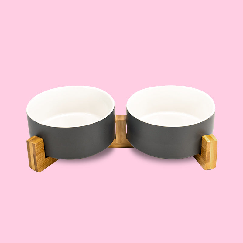the front view of the grey-white clashing dog bowl set on the stand in the pink background