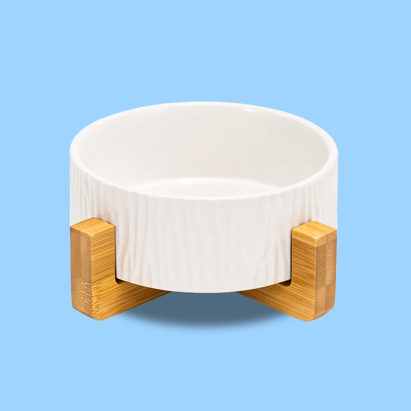 front view of a white bark-patterned dog bowl on its stand in blue background