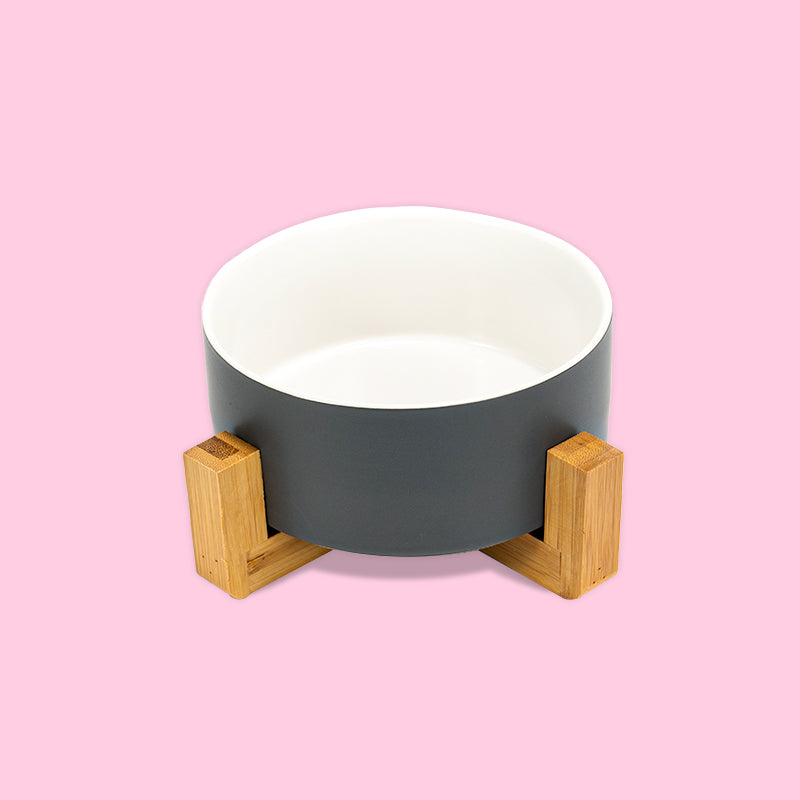 the front view of a grey-white clashing dog bowl on the stand in the pink background