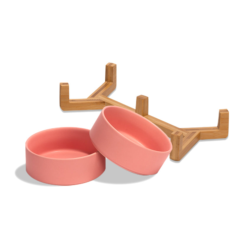 two cute pink ceramic dog bowls and their stand are separately placed