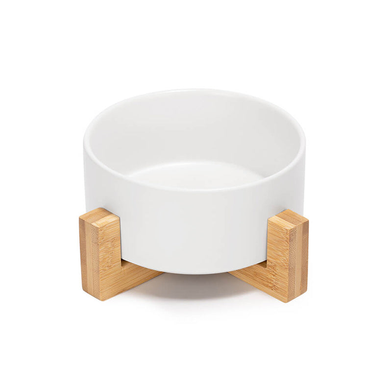 a cute white ceramic dog bowl with bamboo stand