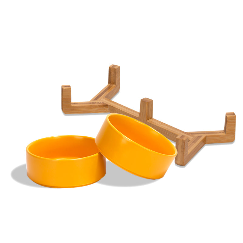 two cute yellow pet bowls and their stand are separately placed