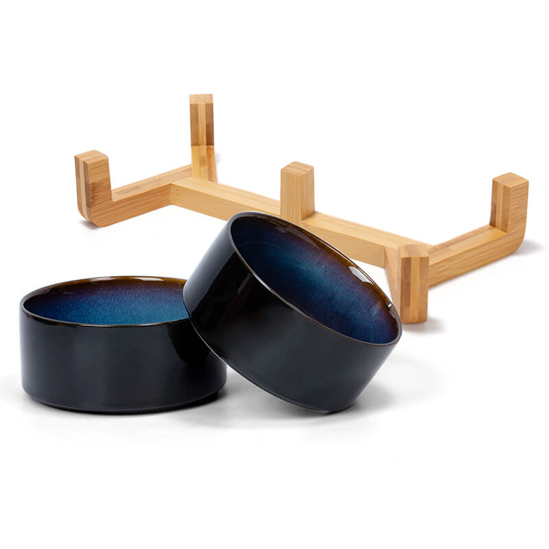 two ceramic dog bowl with starry sky pattern and their bamboo stand are placed separately