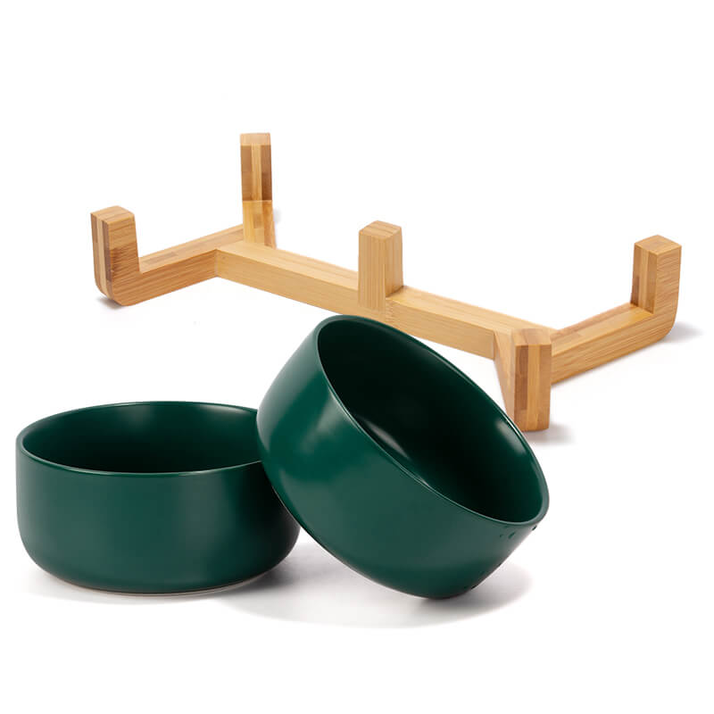 two green round ceramic dog bowls and their bamboo stand are placed separately