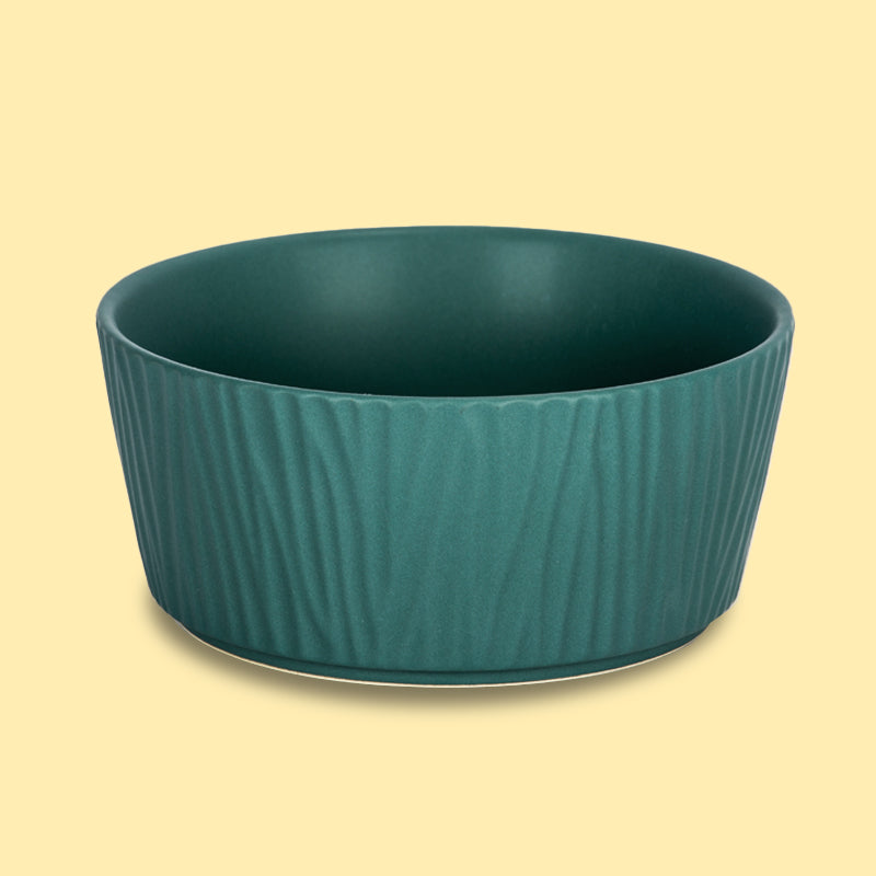 the front view of the bark-patterned large green ceramic dog bowl in the yellow background