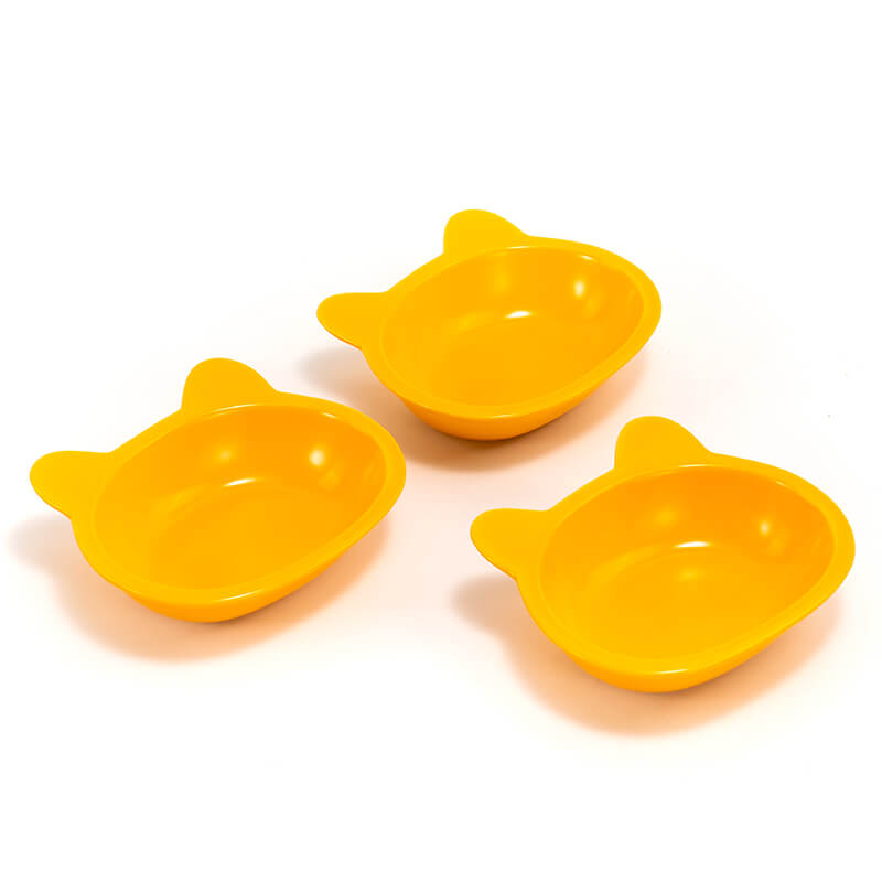 three neatly placed lovely yellow cat-shaped cat dishes