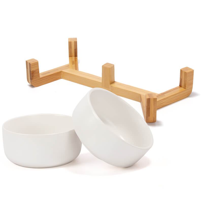 two white round dog bowls and their bamboo stand are placed separately